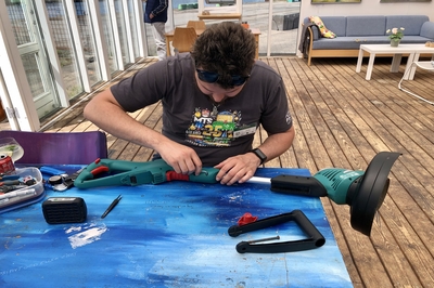 Alain repairing a lawn mower